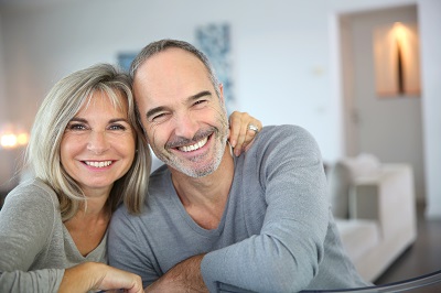 Image of a middle aged couple smiling with healthy teeth.